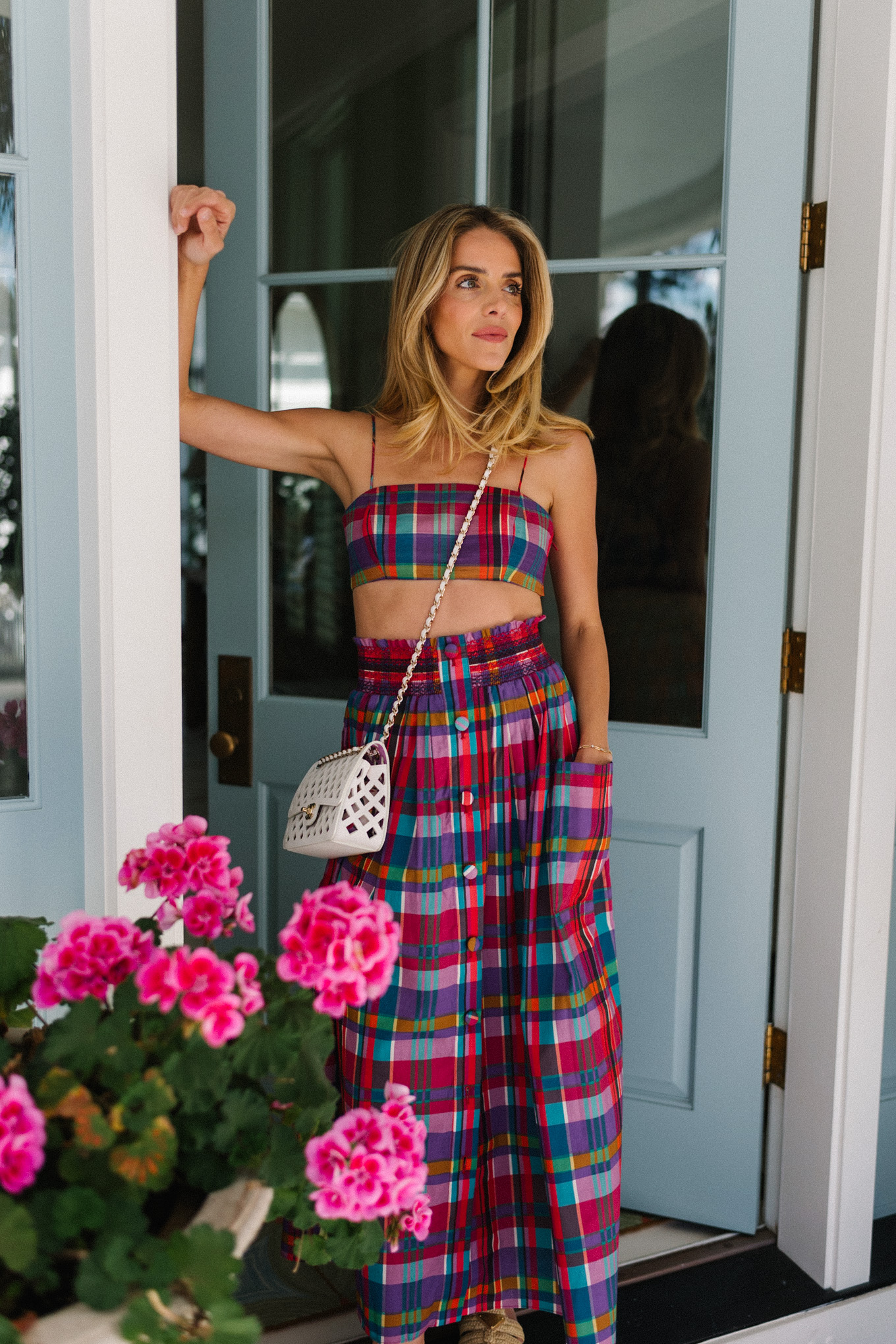 pink madras skirt and crop top set white woven bag