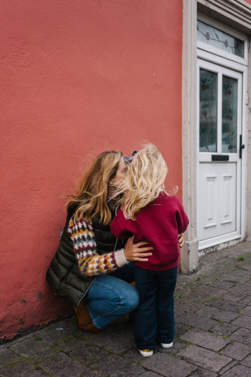 green vest colorful sweater blue jeans tan booties