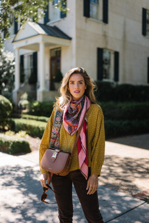 gold blouse pink silk scarf brown cords brown leather bag