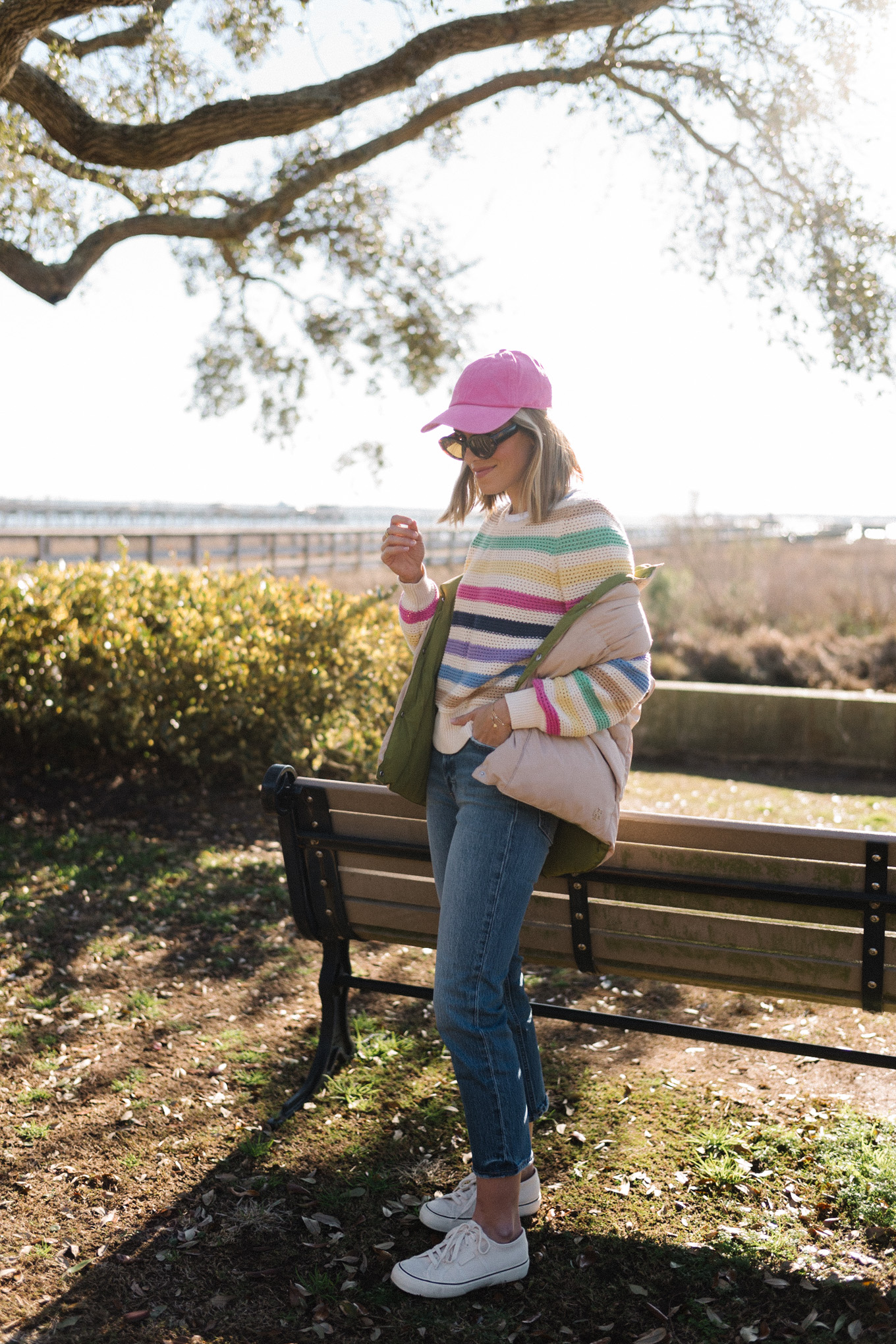 Rainbow striped sweater, pink hat, neutral puffer vest