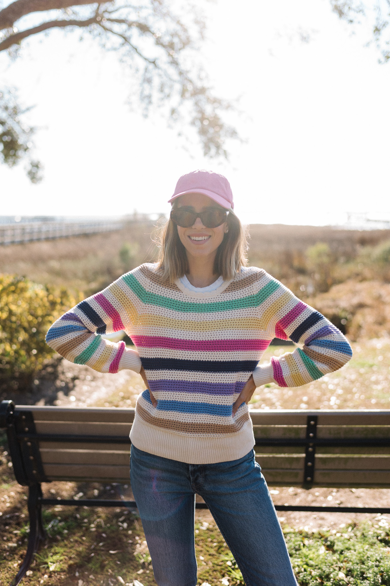 Rainbow striped sweater, pink hat, neutral puffer vest