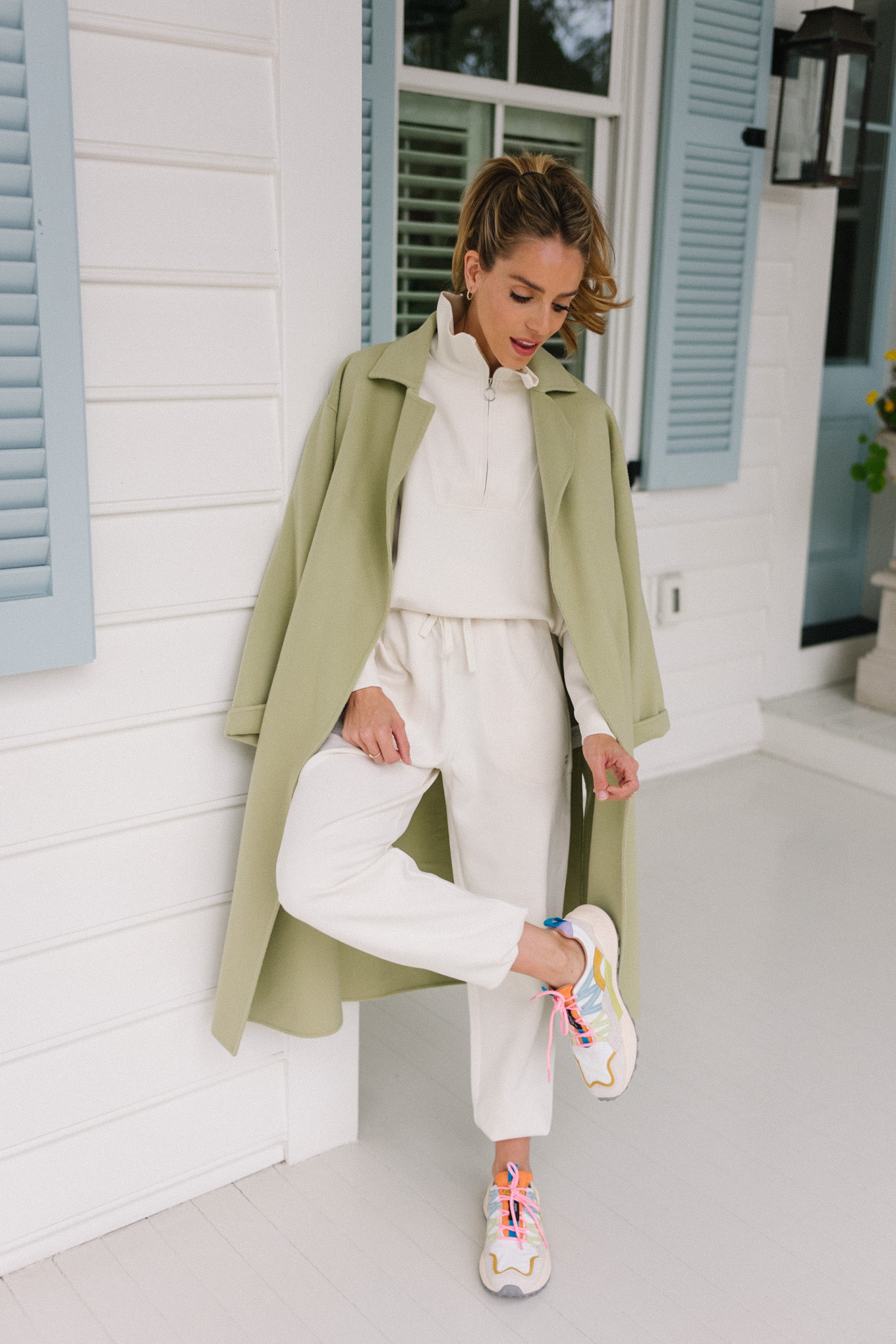 white sweatsuit green coat bright sneakers