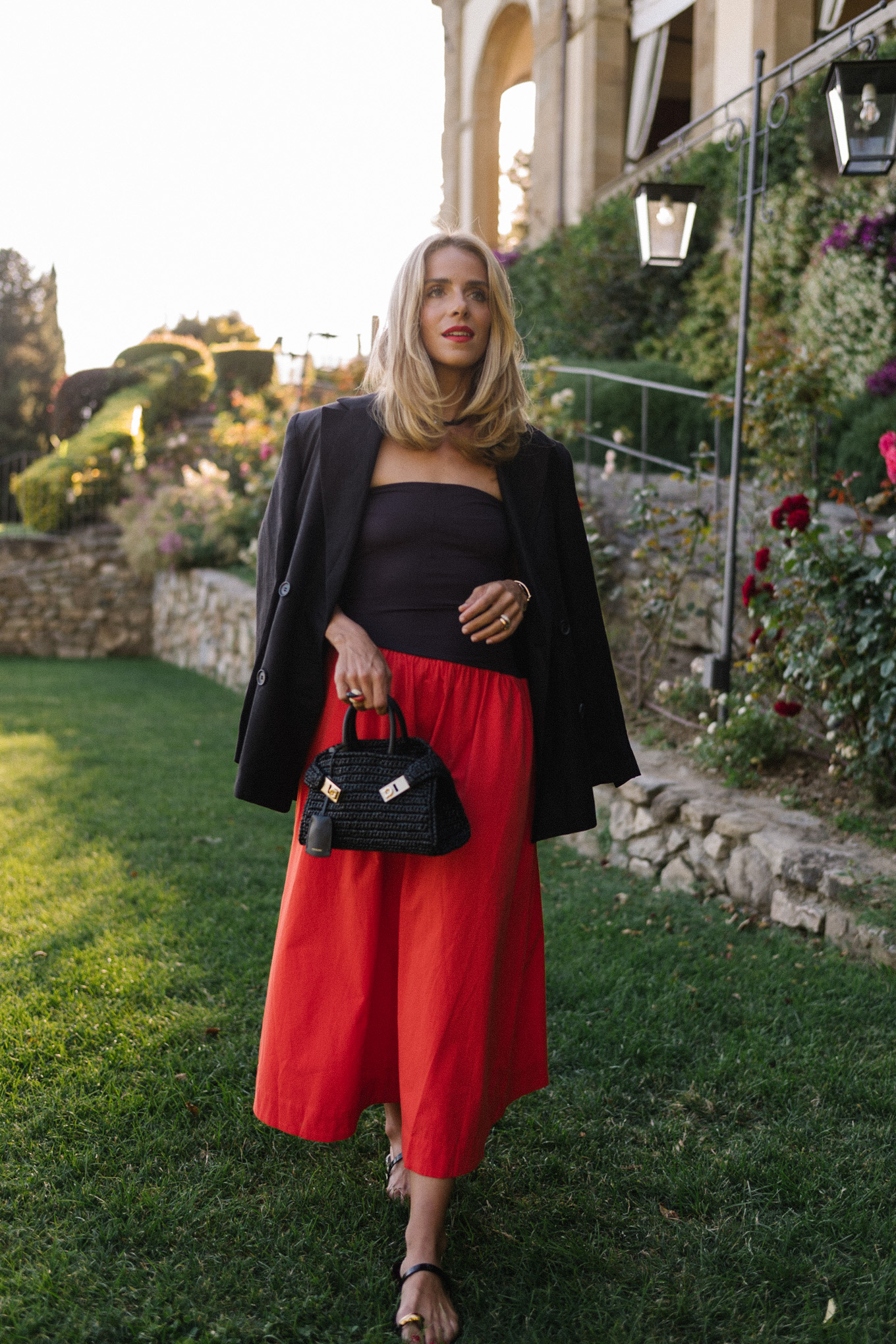 Black blazer, black and red midi dress, black straw bag, black leather sandals