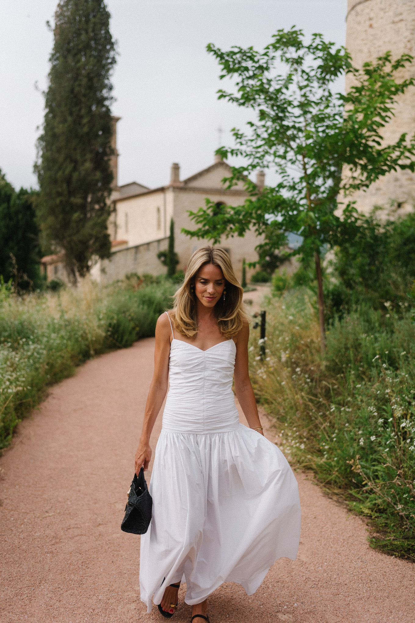 White maxi dress, black leather sandals, black straw bag