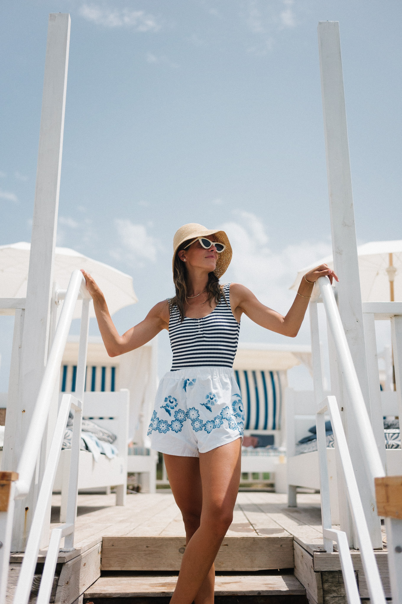 navy white striped swimsuit white blue embroidered shorts straw bucket hat white sunglasses