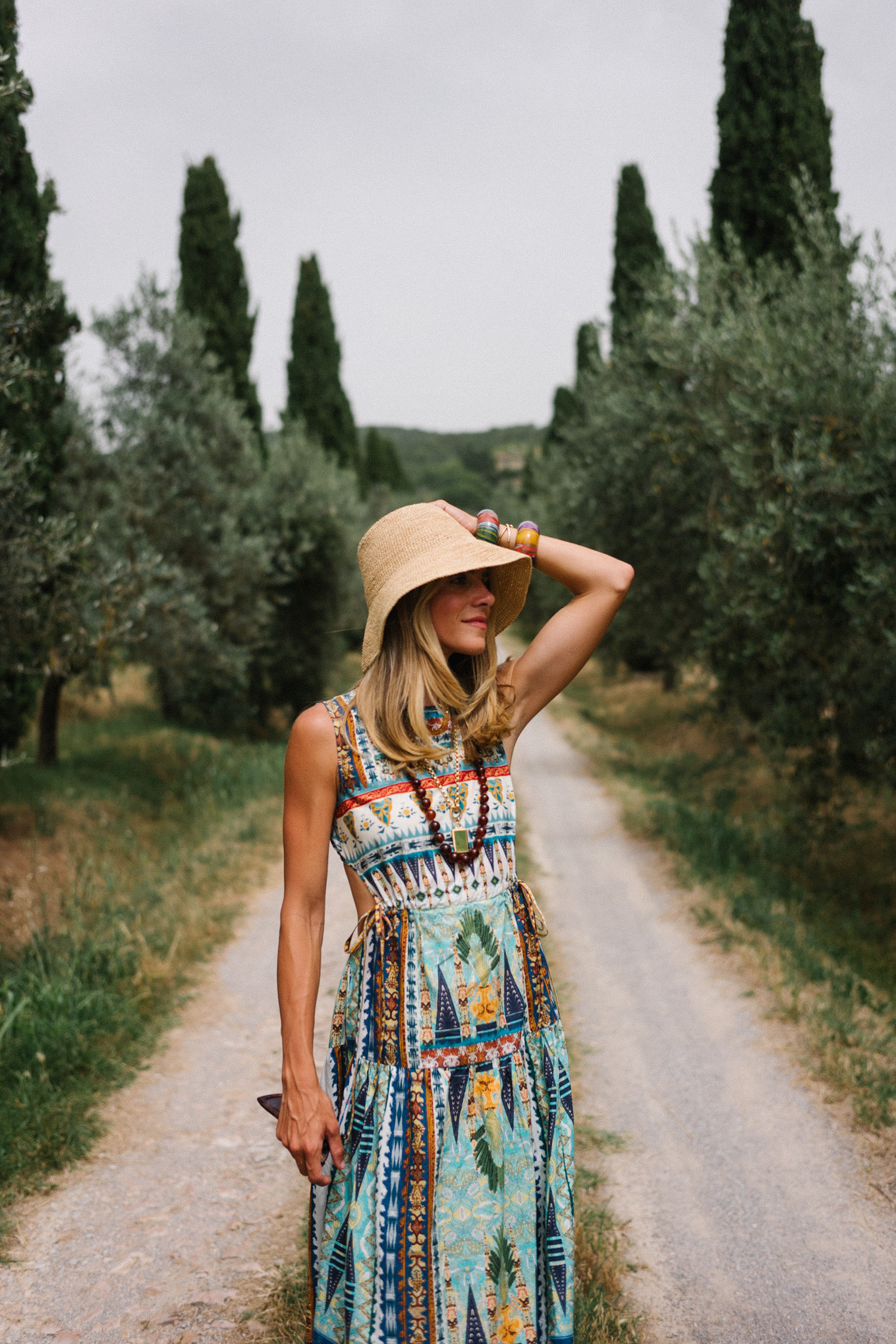 Patterned maxi dress, woven bucket hat, cream sandals, and cream woven bag