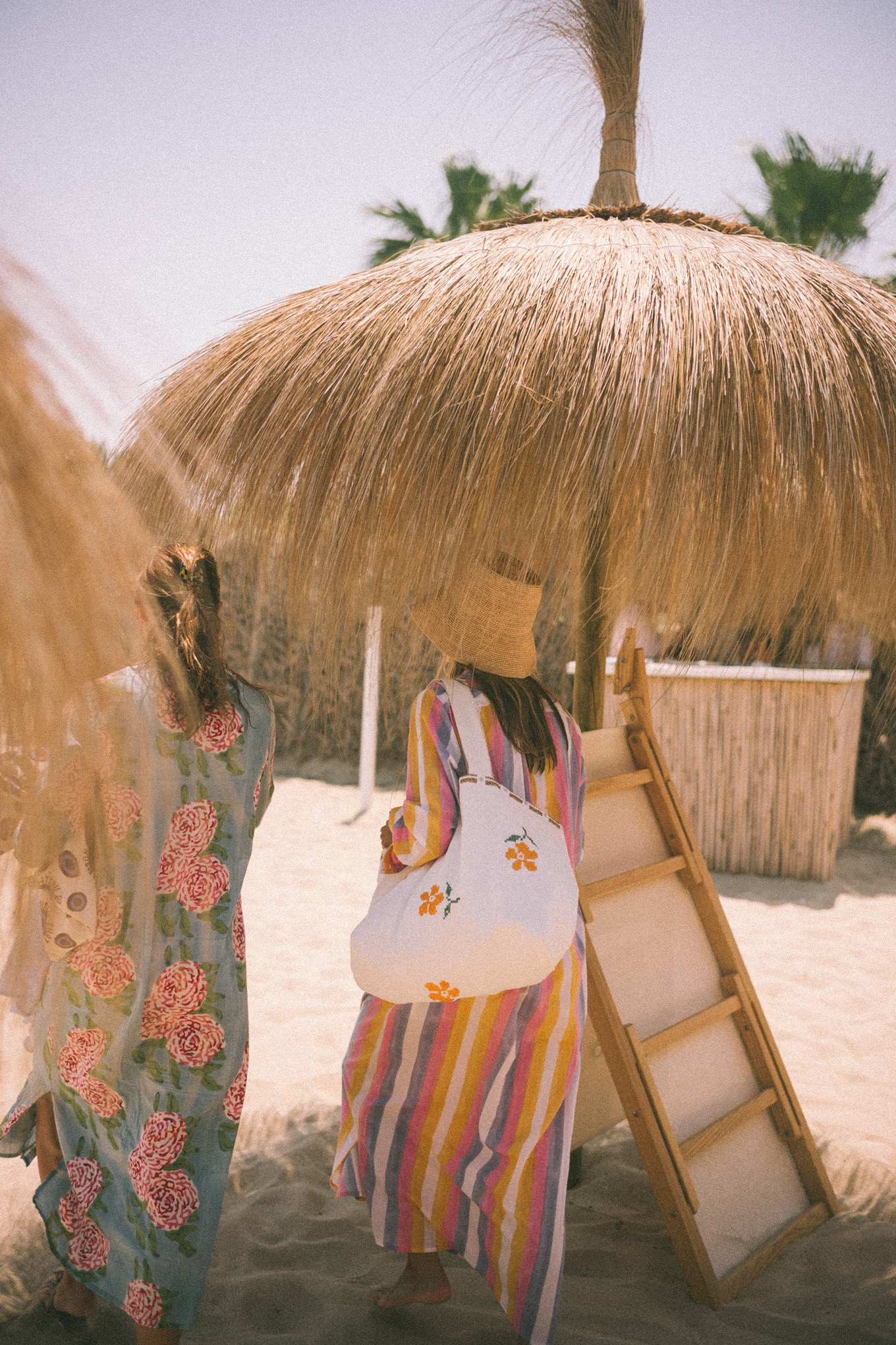 Pink and purple striped cover-up straw hat and white sunglasses