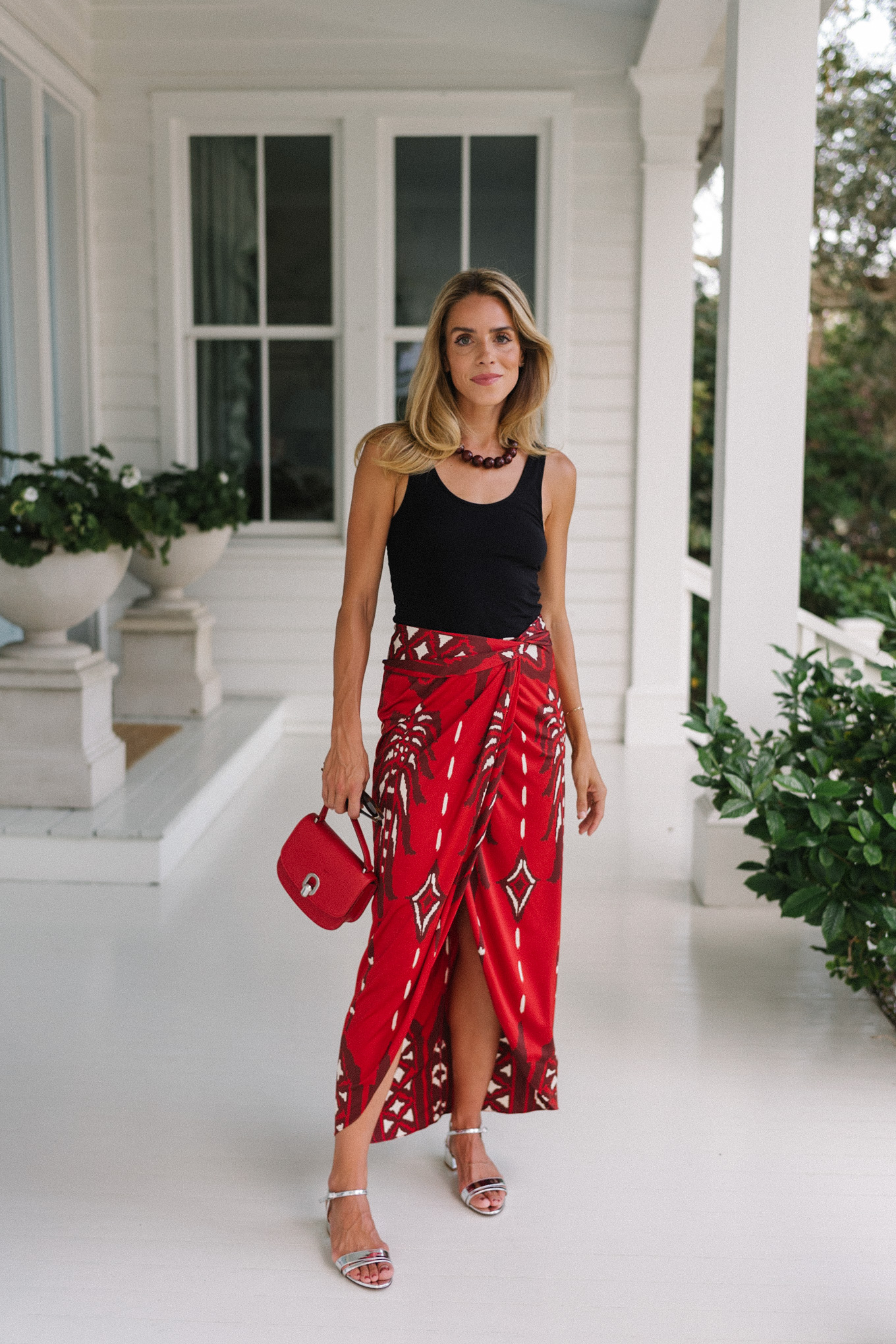 Black tank top, red maxi wrap skirt, silver heels, red bag