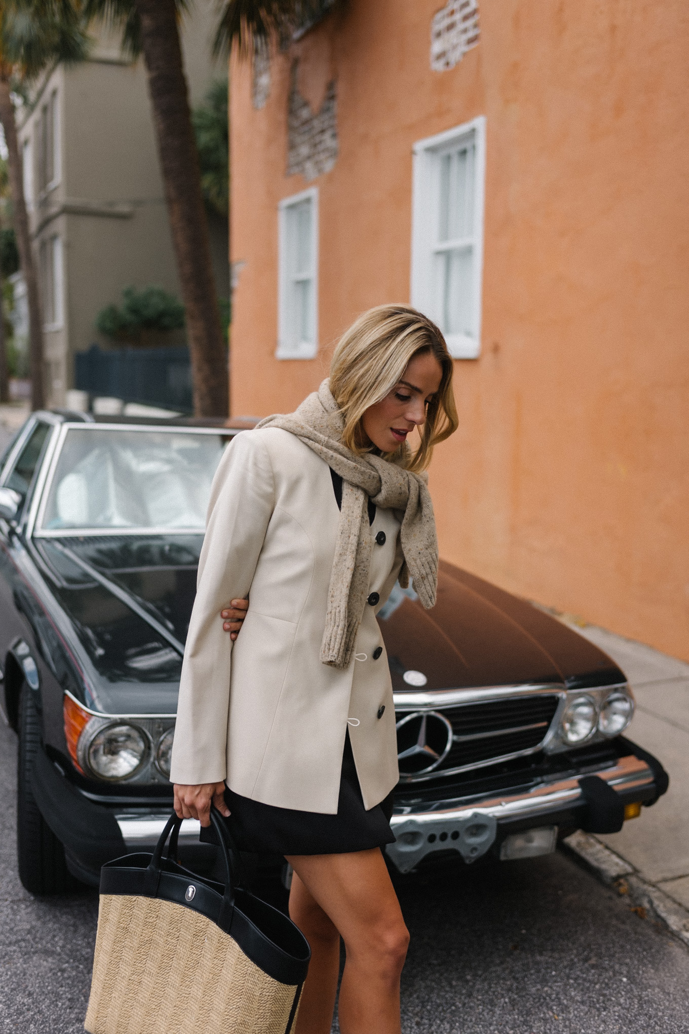 black mini dress cream jacket straw bag silver pumps