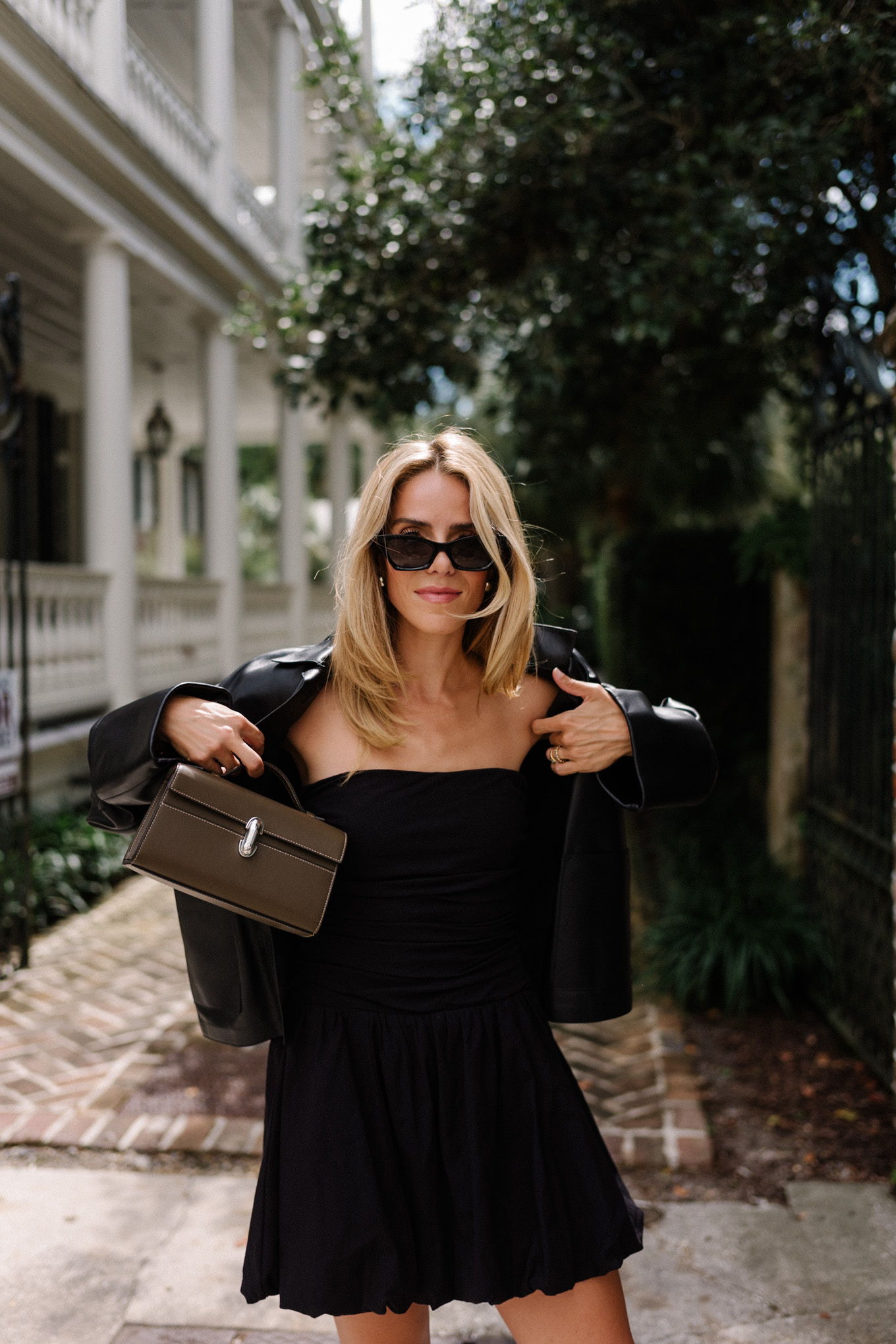 Black mini dress, black leather jacket, snakeskin mules, leather bag