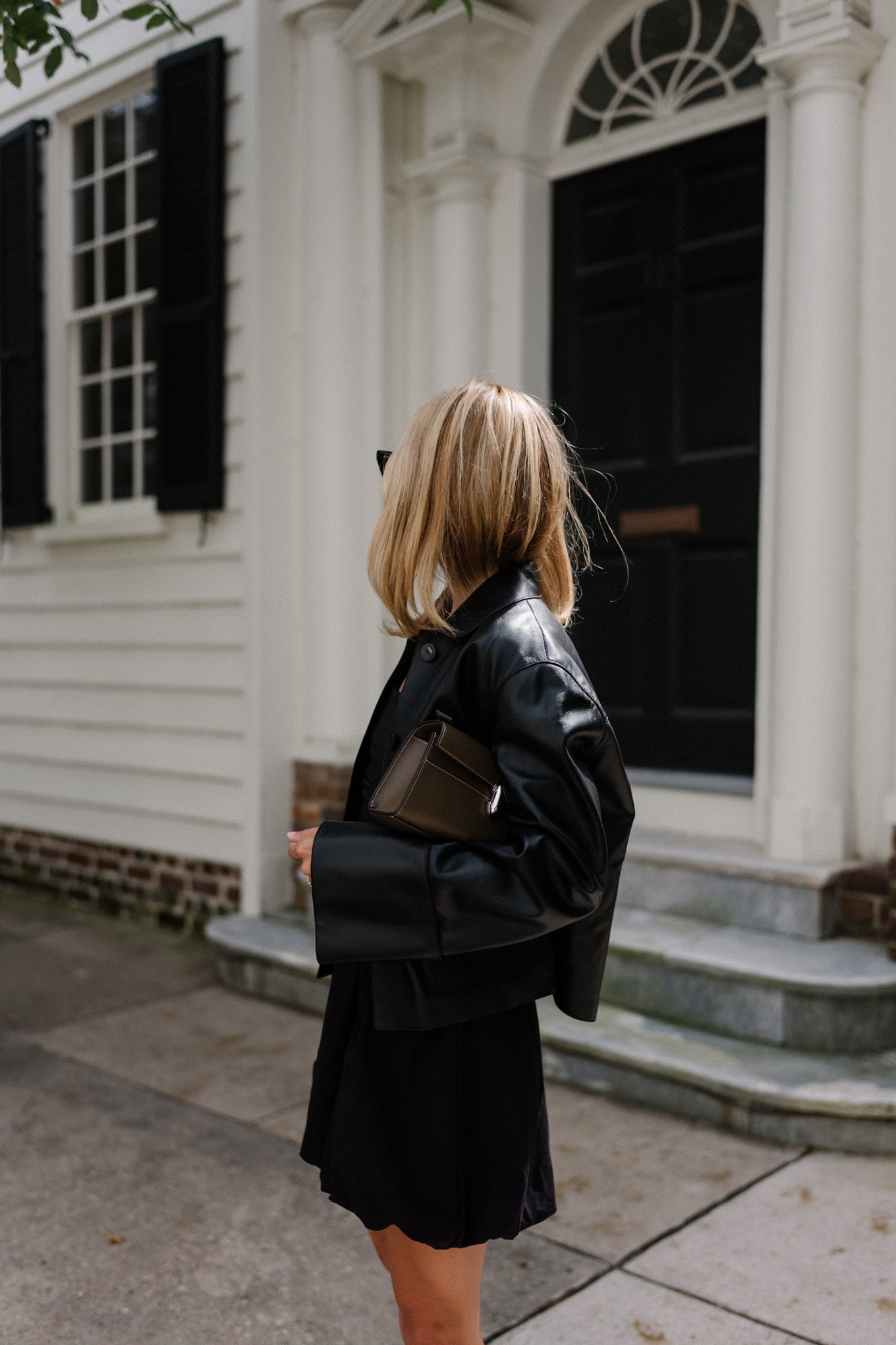 Black mini dress, black leather jacket, snakeskin mules, leather bag