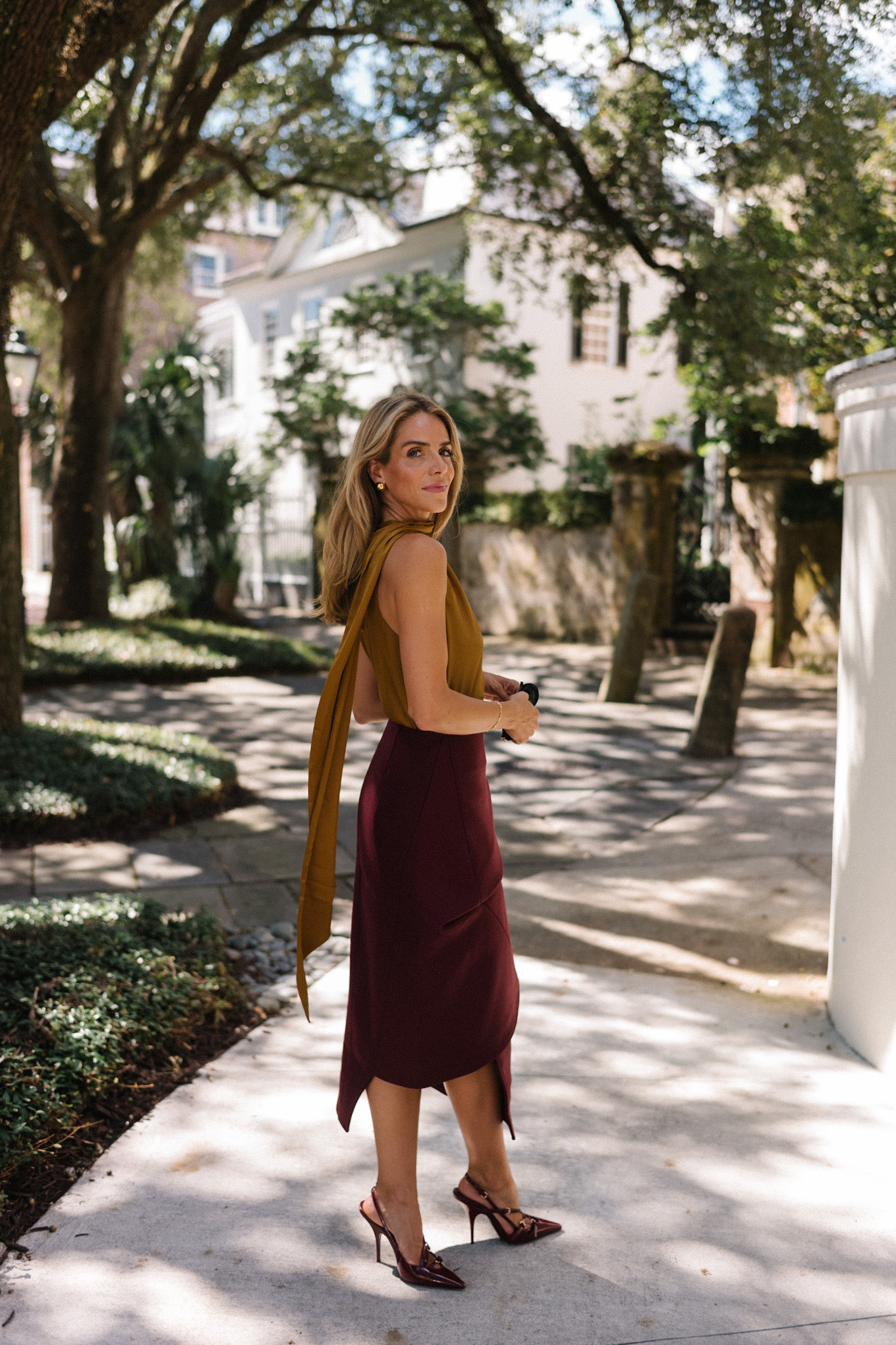 Burgundy leather jacket, burgundy midi skirt, gold silk shirt