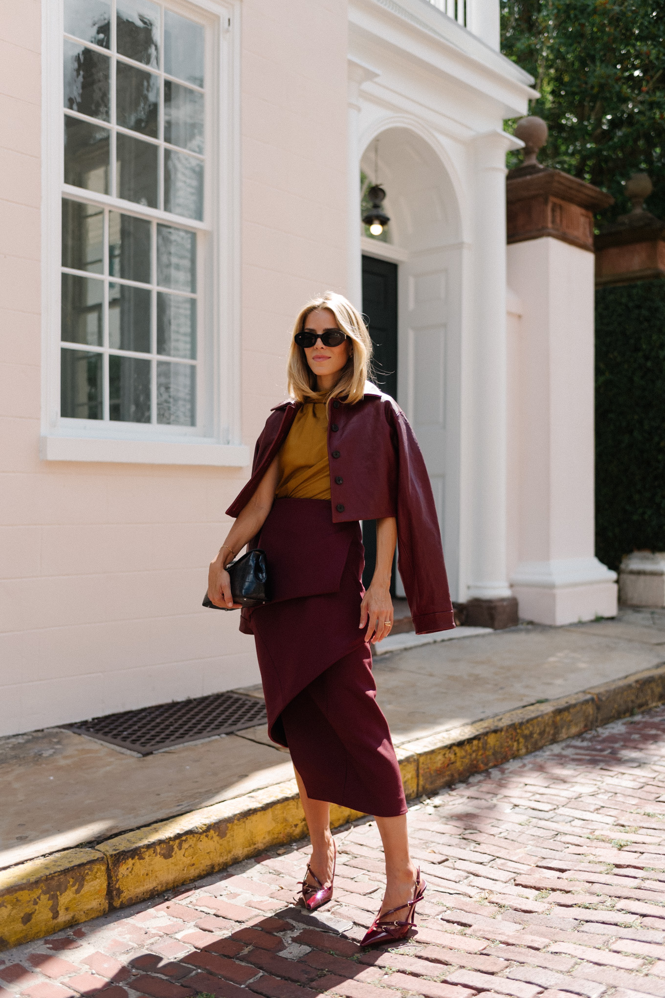 Burgundy leather jacket, burgundy midi skirt, gold silk shirt