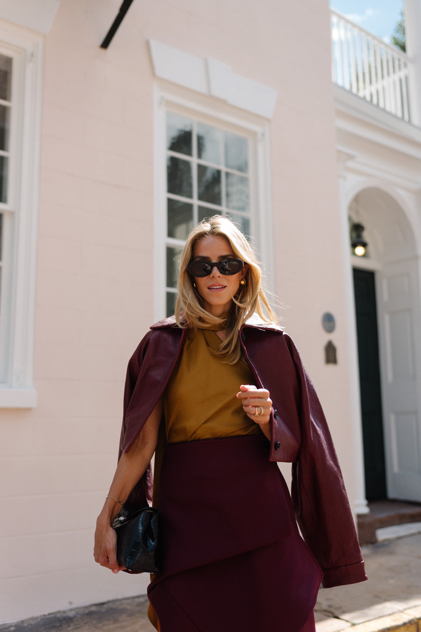 Burgundy leather jacket, burgundy midi skirt, gold silk shirt