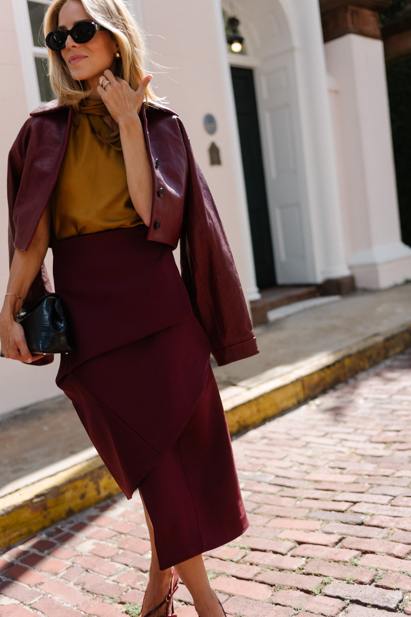 Burgundy leather jacket, burgundy midi skirt, gold silk shirt