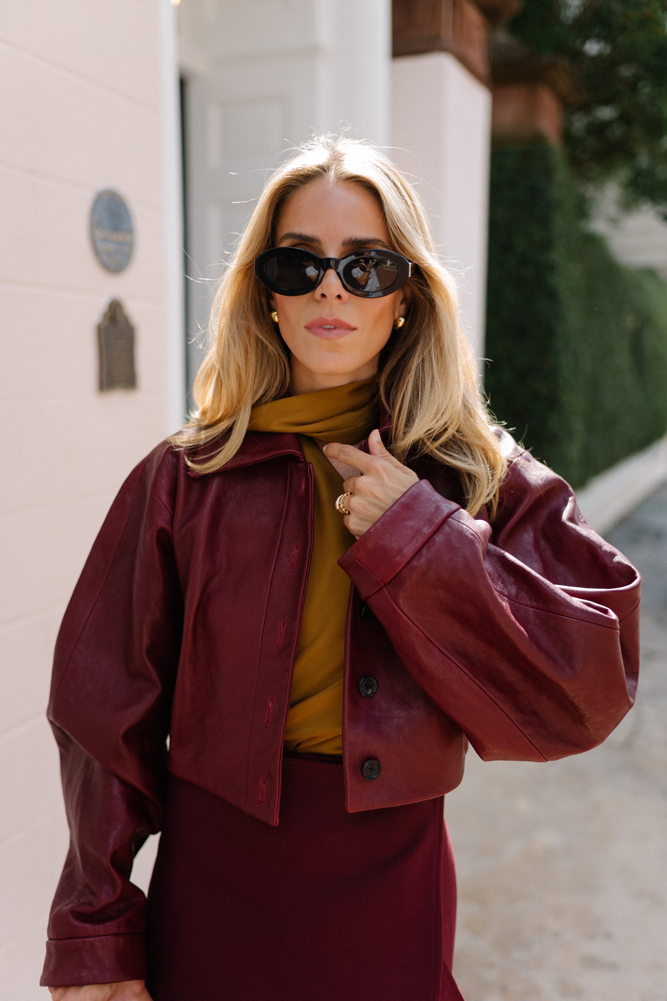 Burgundy leather jacket, burgundy midi skirt, gold silk shirt