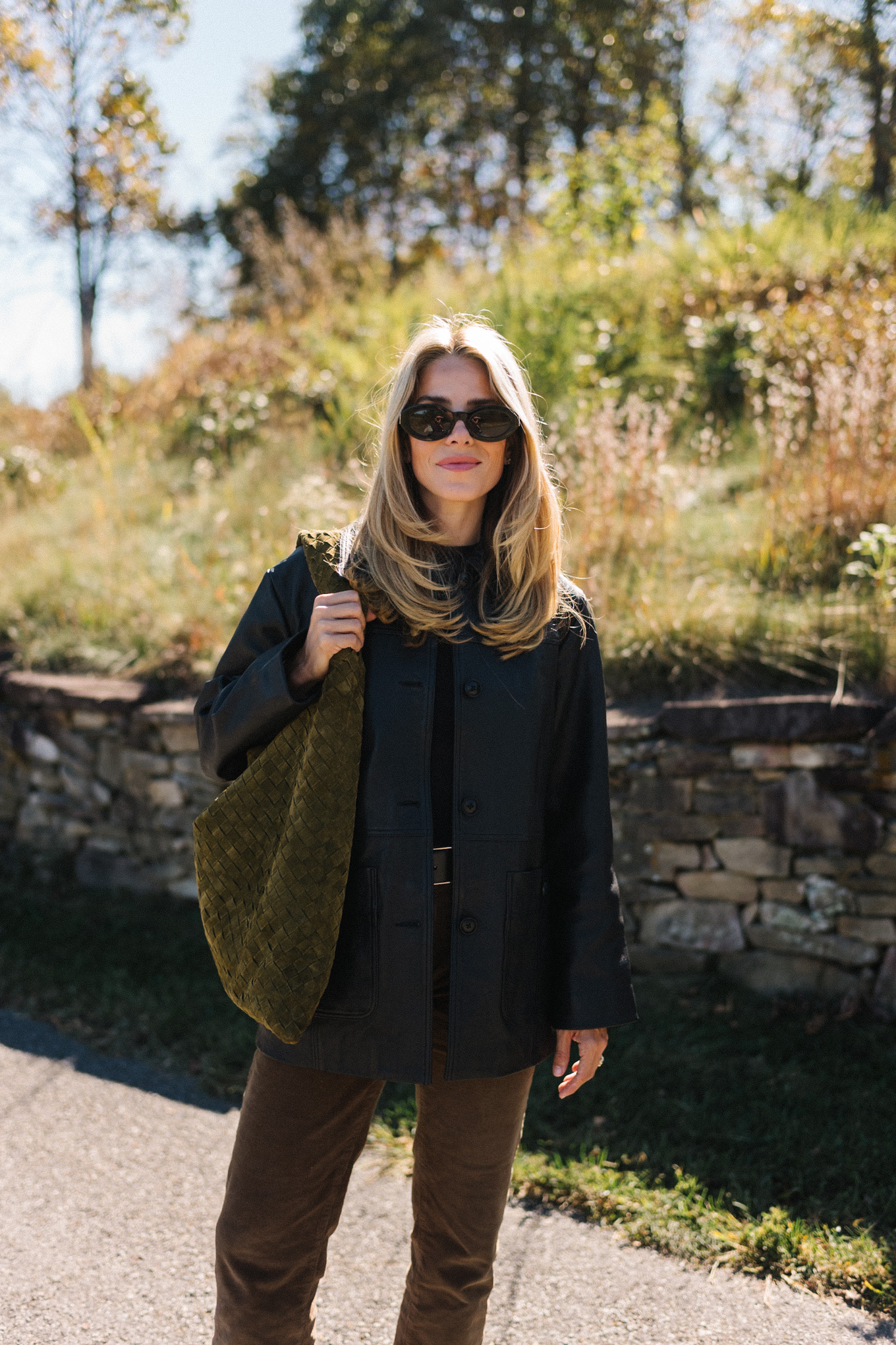 Black leather jacket, black sweater, corduroy trousers, suede bag