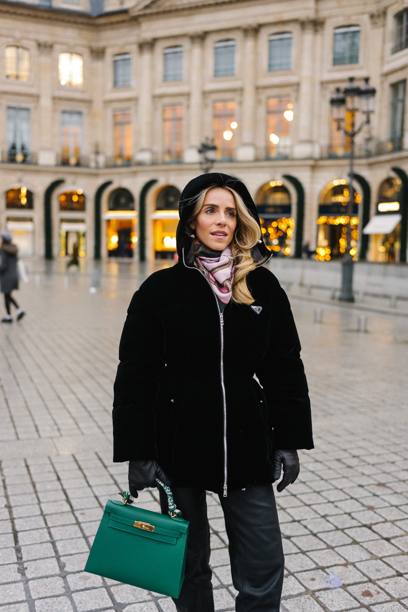 black velvet puffer coat black pants green handbag in paris