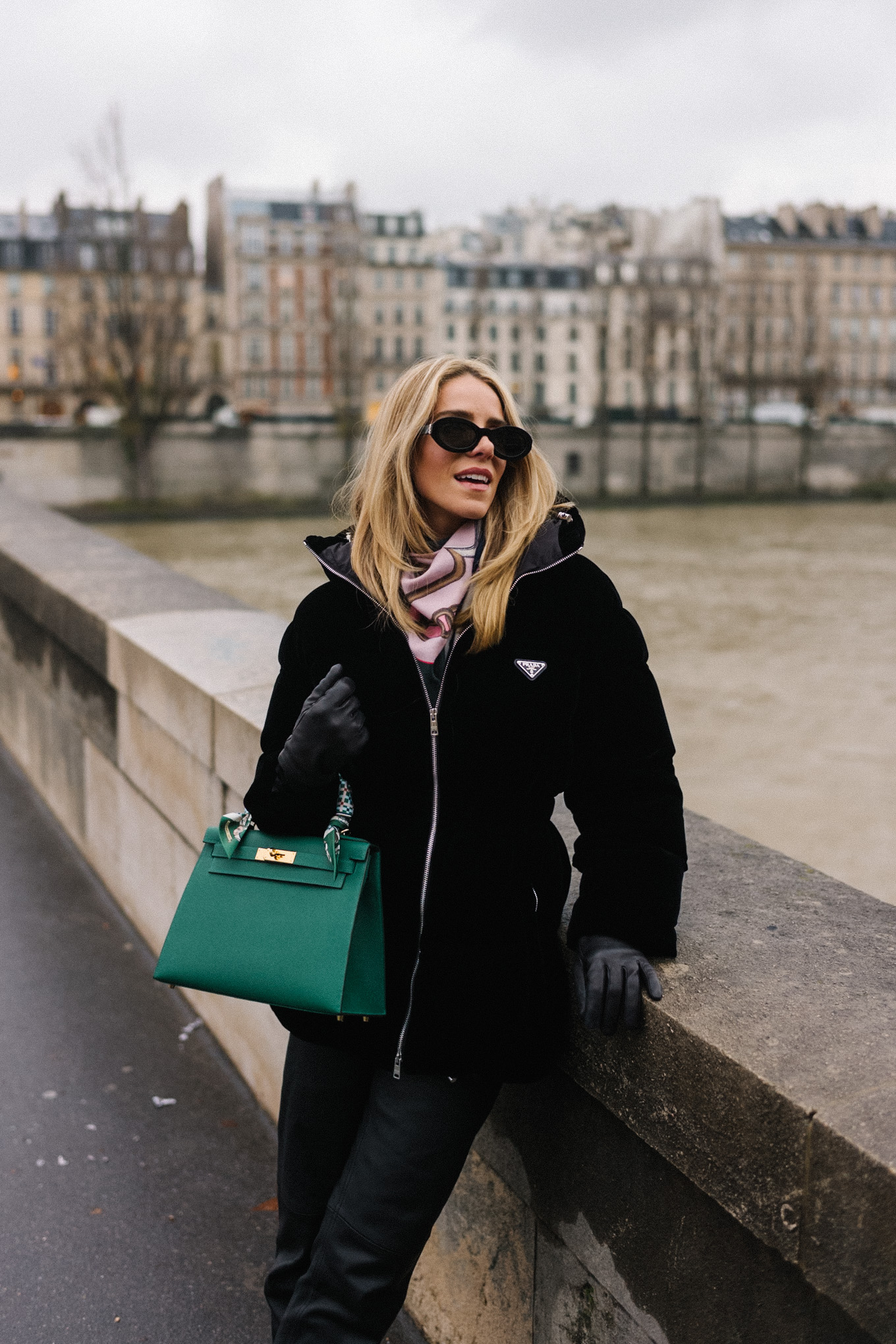 black velvet puffer coat black pants green handbag in paris