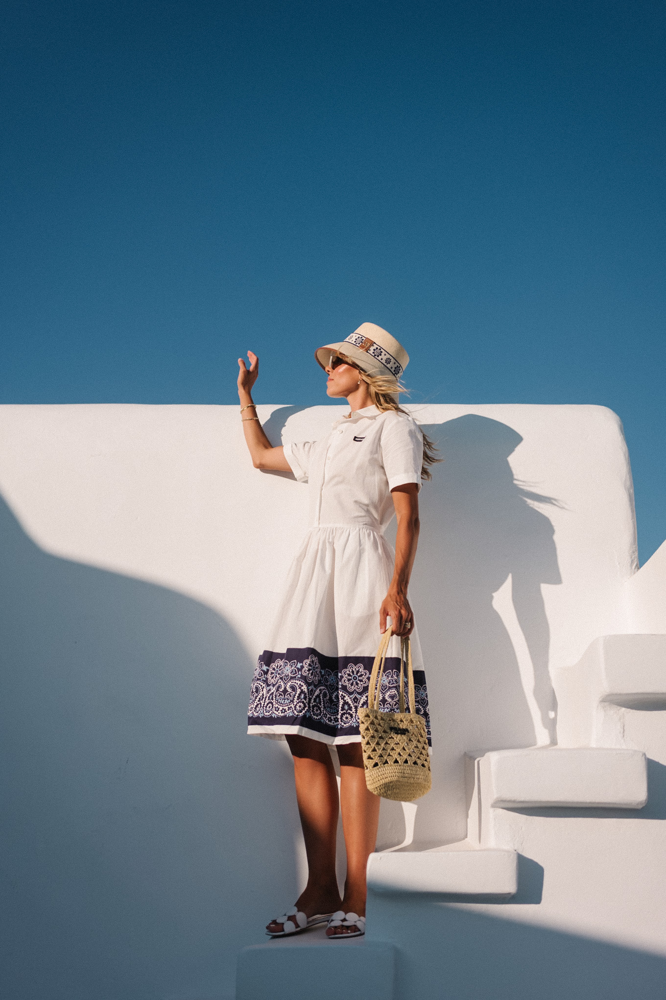 blue white shirtdress straw bucket hat woven bag white heeled sandals