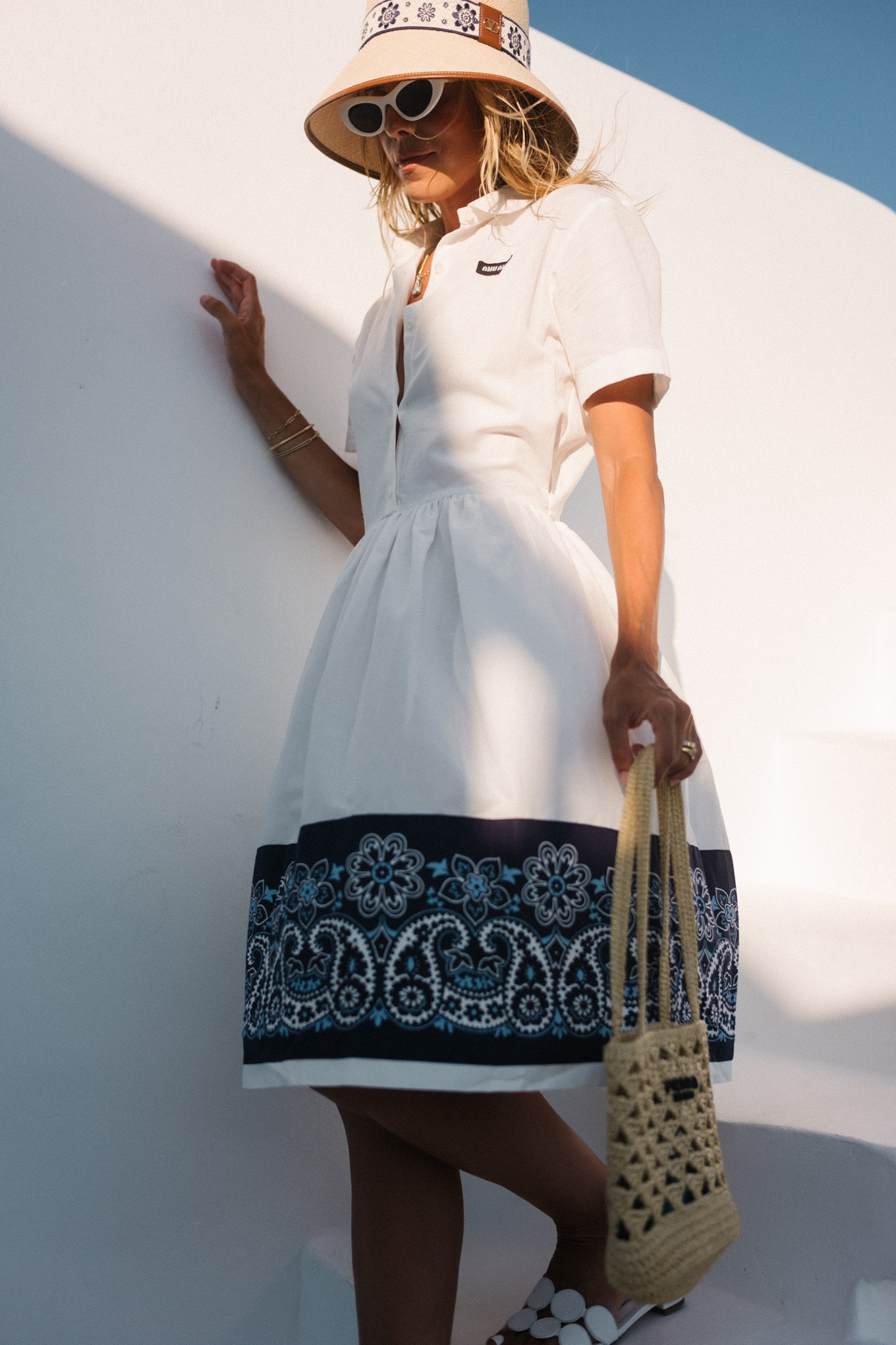 blue white shirtdress straw bucket hat woven bag white heeled sandals