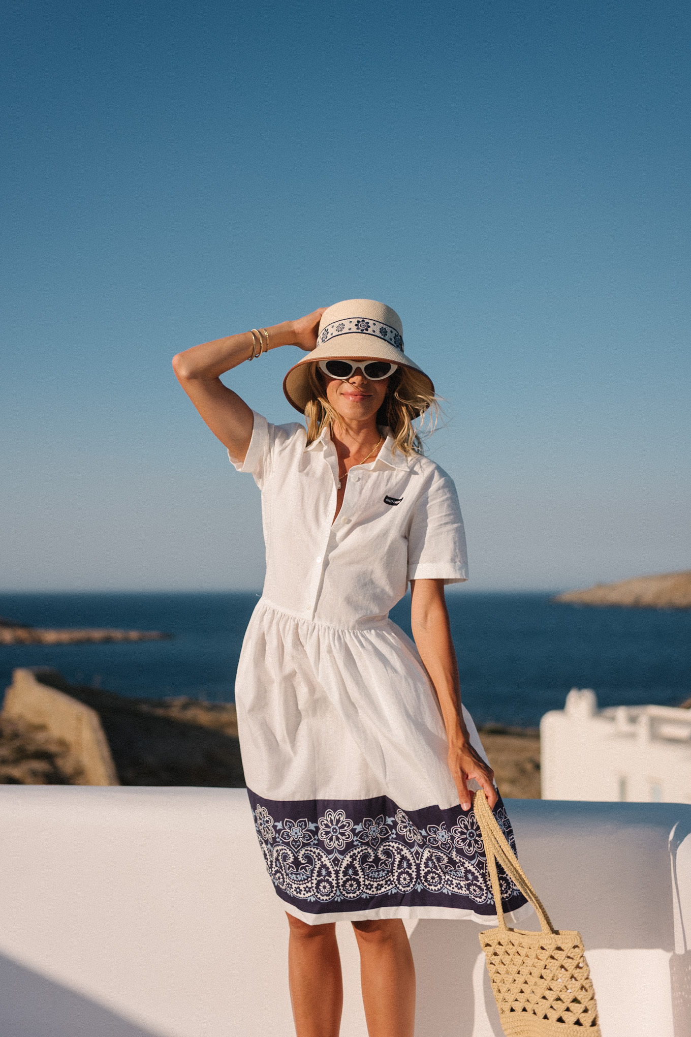 blue white shirtdress straw bucket hat woven bag white heeled sandals