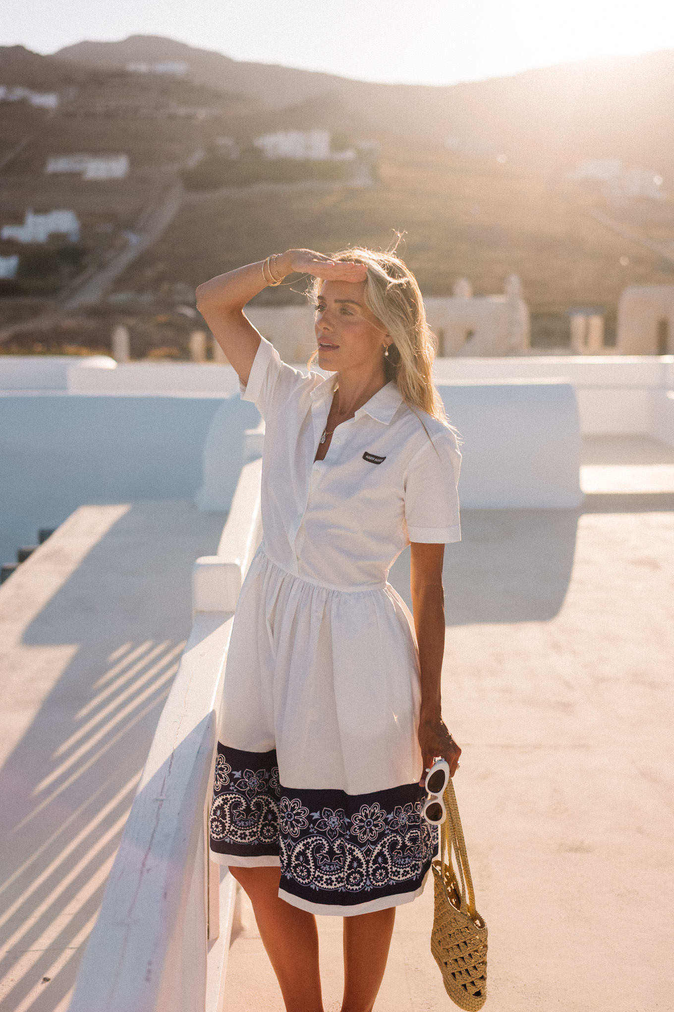 blue white shirtdress straw bucket hat woven bag white heeled sandals