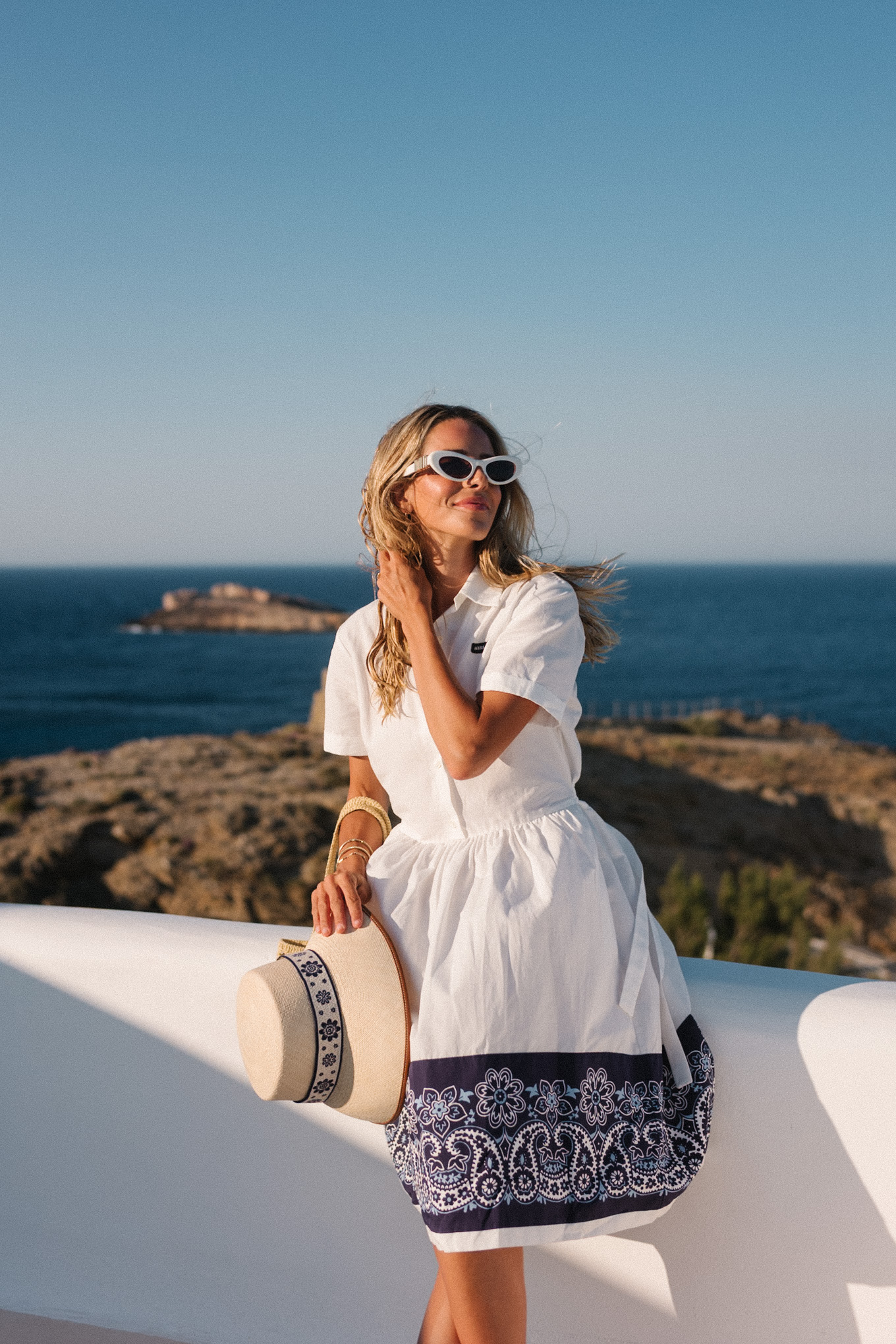 blue white shirtdress straw bucket hat woven bag white heeled sandals