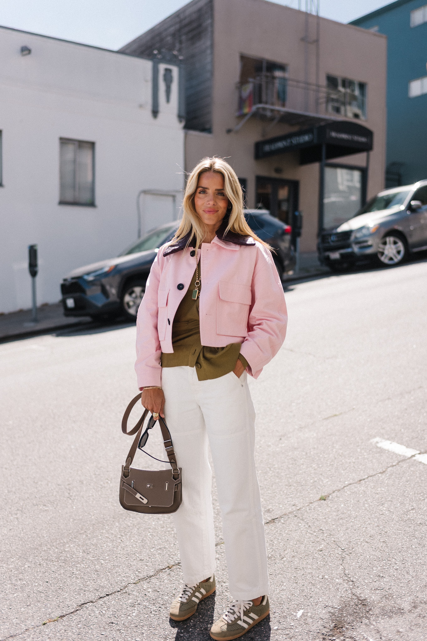 pink cropped barn jacket white denim green sweater green sneakers