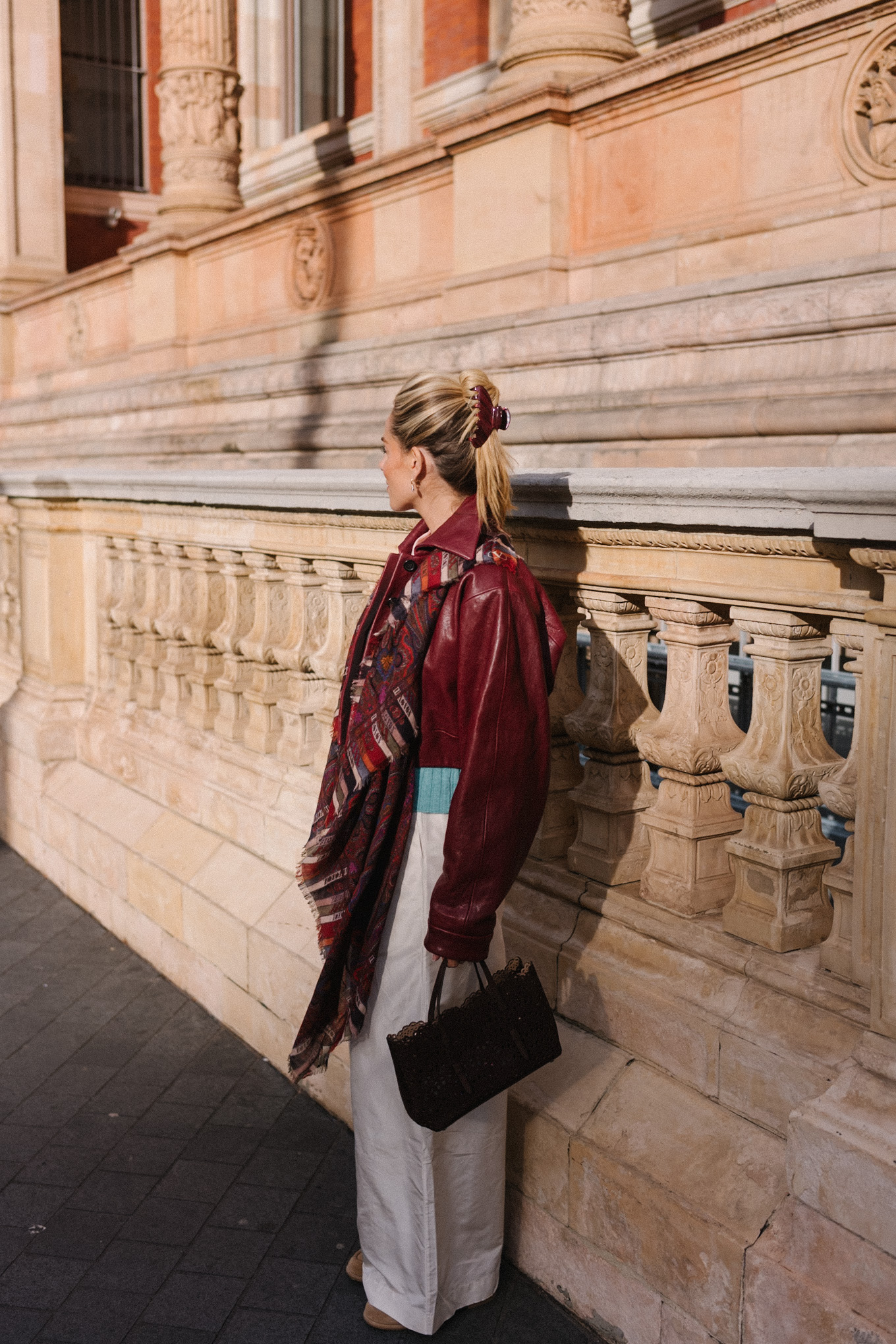 maroon leather jacket striped scarf turquoise sweater white button down shirt cream wide leg pants