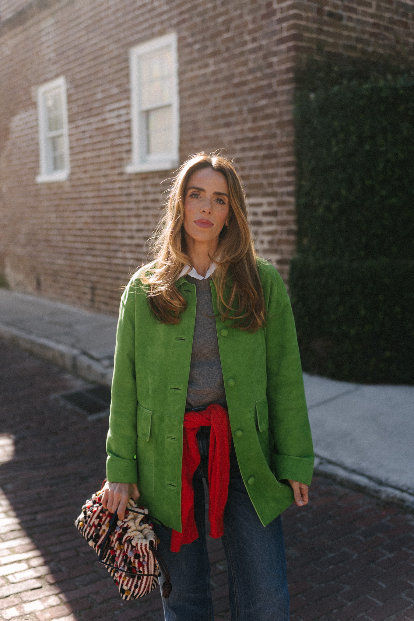 green suede jacket grey wool sweater red cashmere sweater wide leg denim black flats