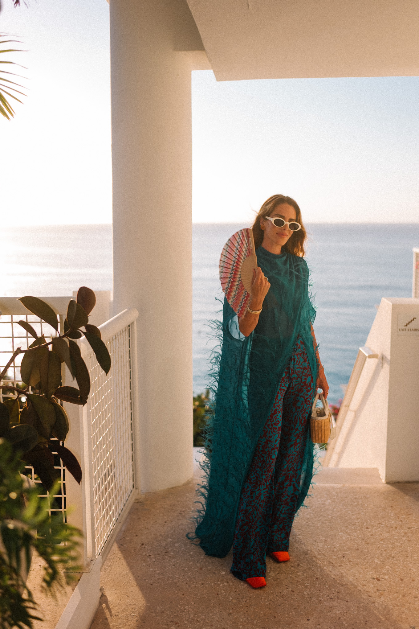 turquoise feathered maxi top turquoise printed wide leg pants wicker handbag