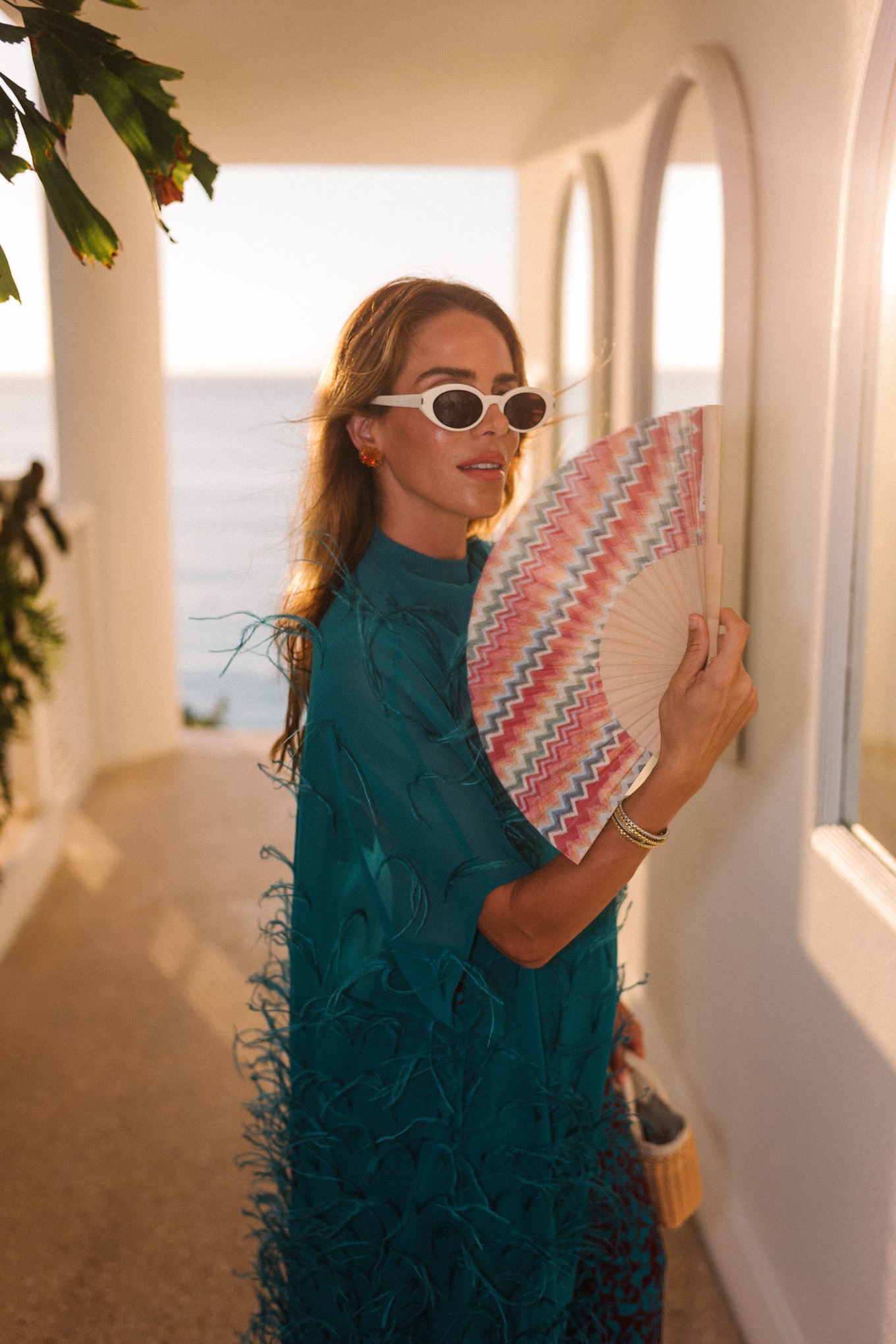 turquoise feathered maxi top turquoise printed wide leg pants wicker handbag