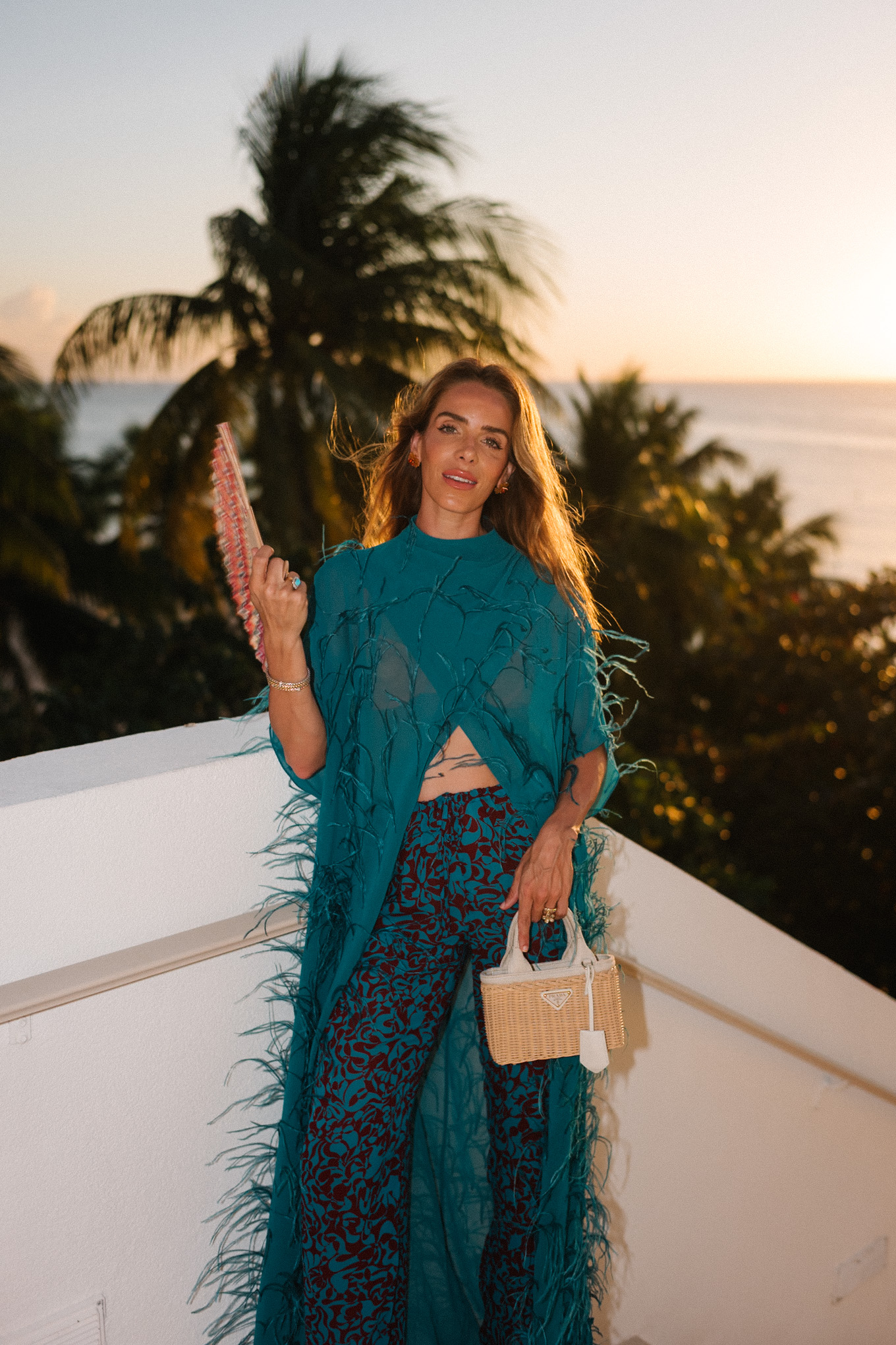 turquoise feathered maxi top turquoise printed wide leg pants wicker handbag