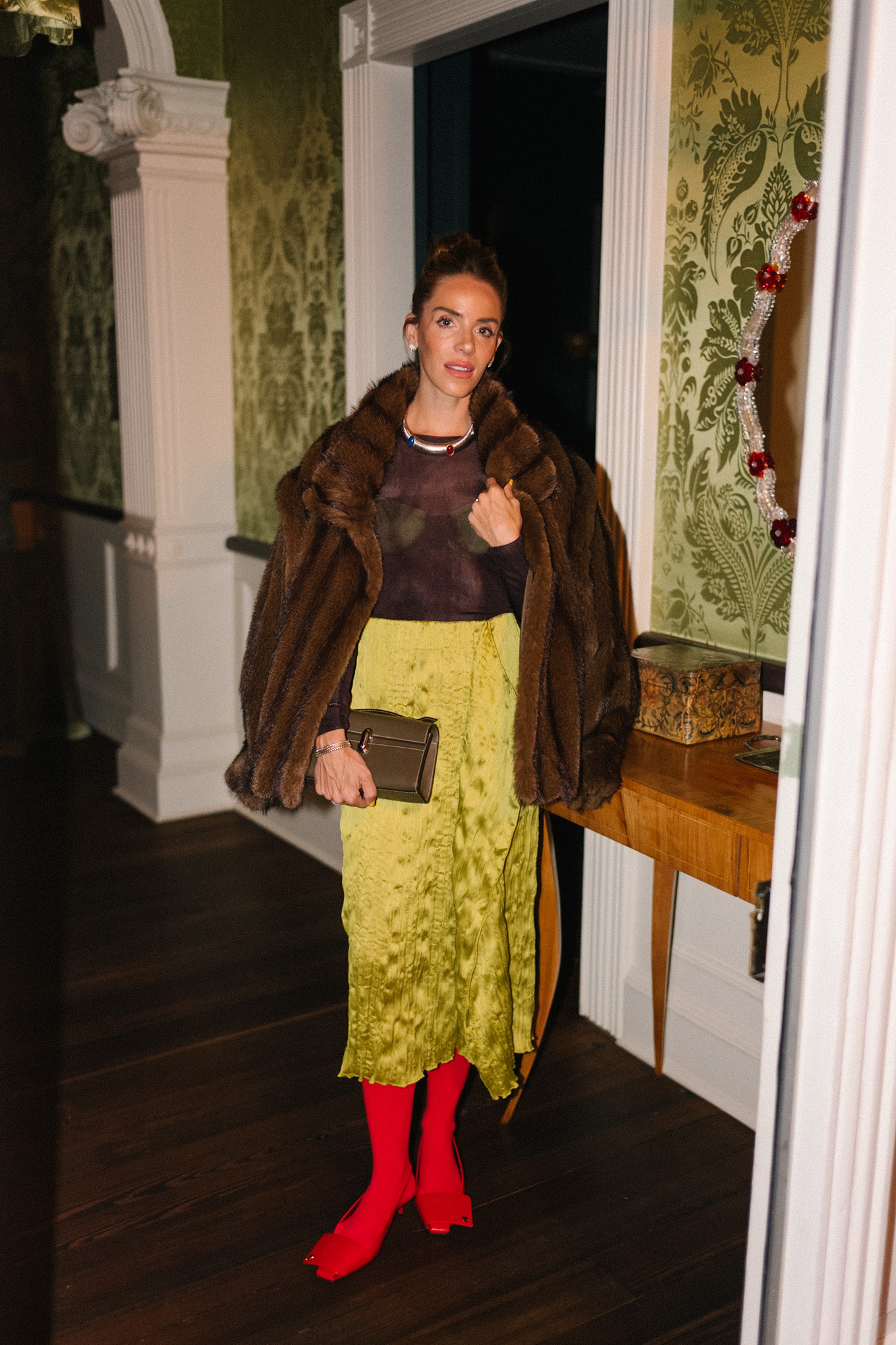 brown faux fur coat brown sheer top green silk skirt red tights red heels