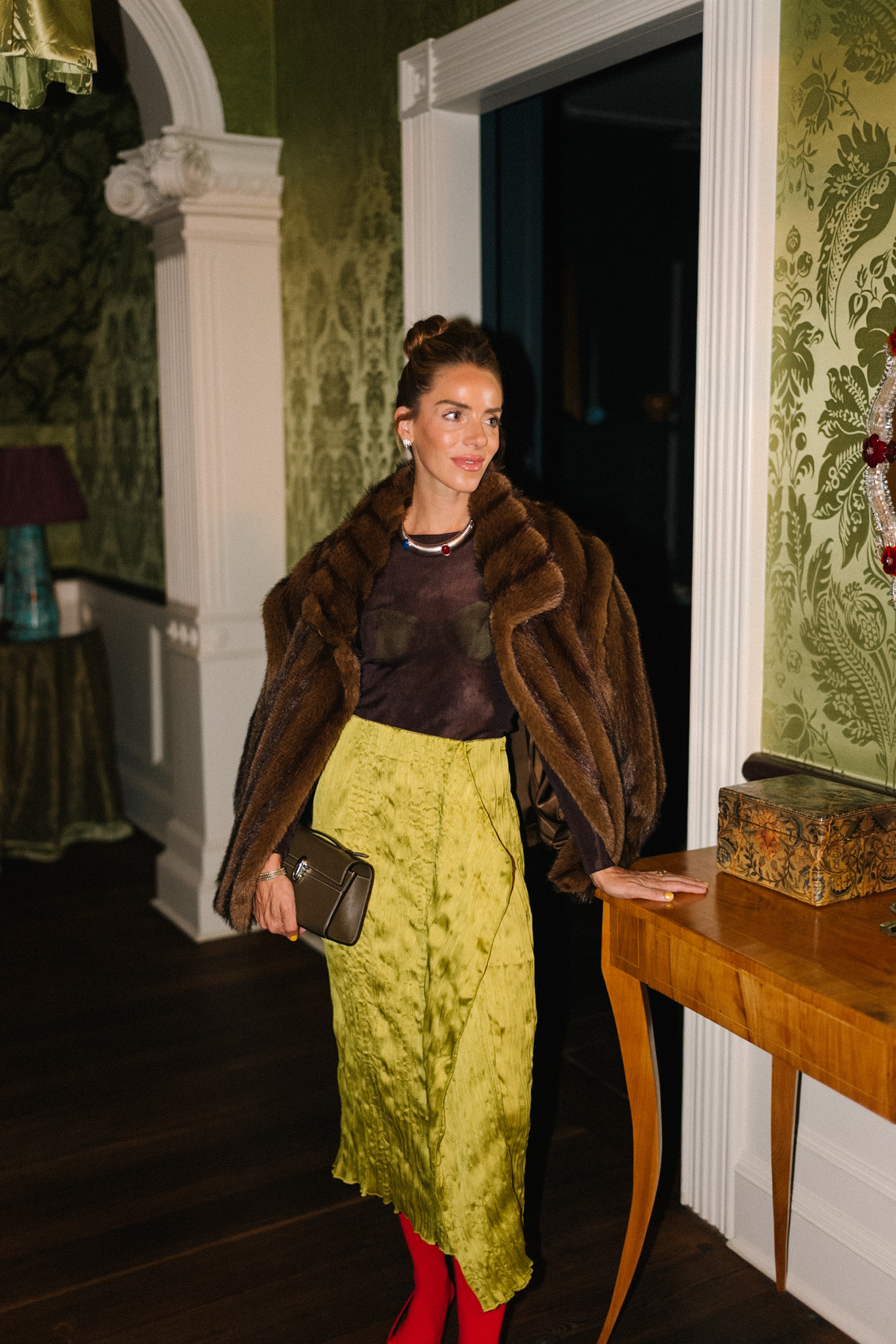 brown faux fur coat brown sheer top green silk skirt red tights red heels