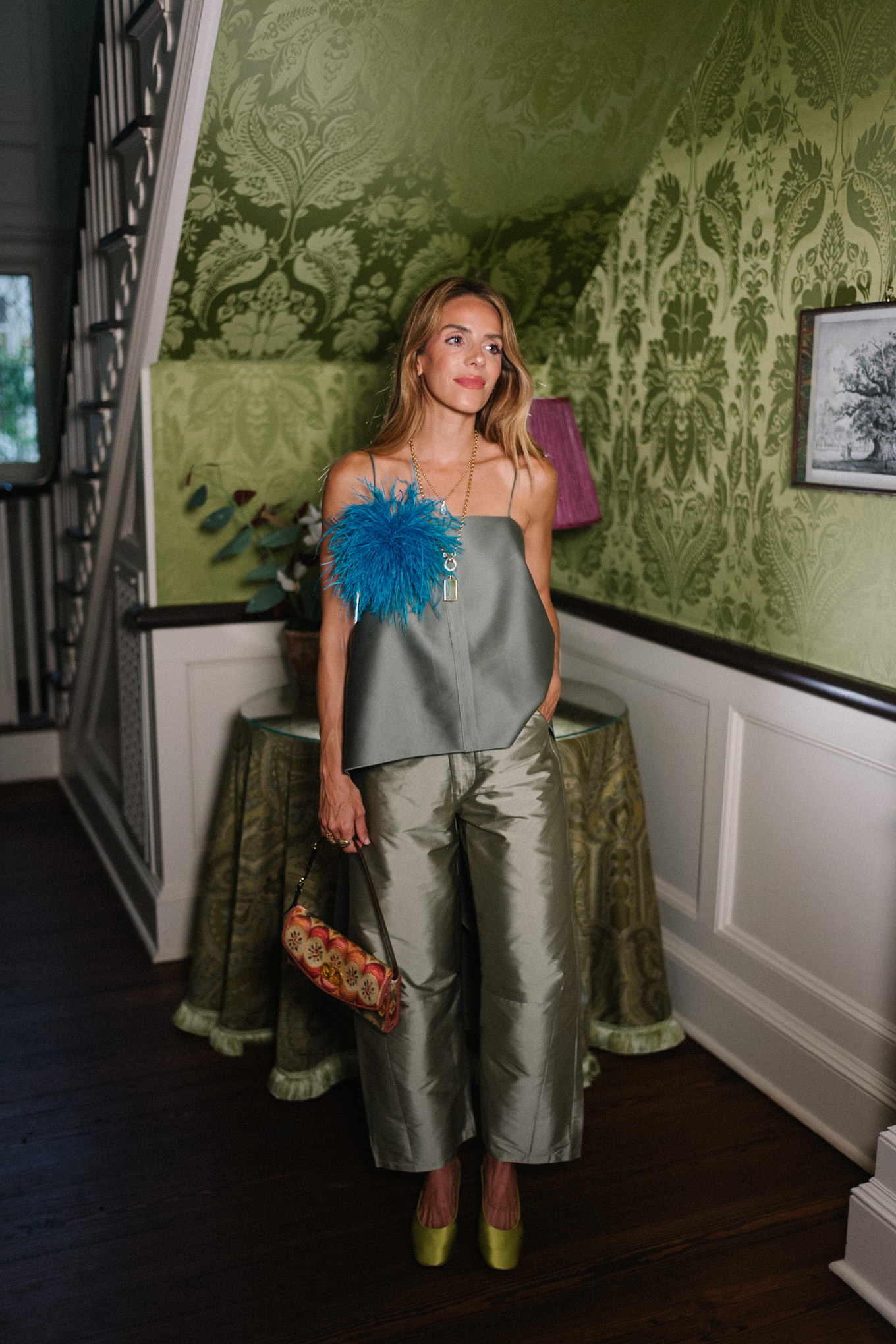 green tank top green taffeta barrel pants blue feather brooch