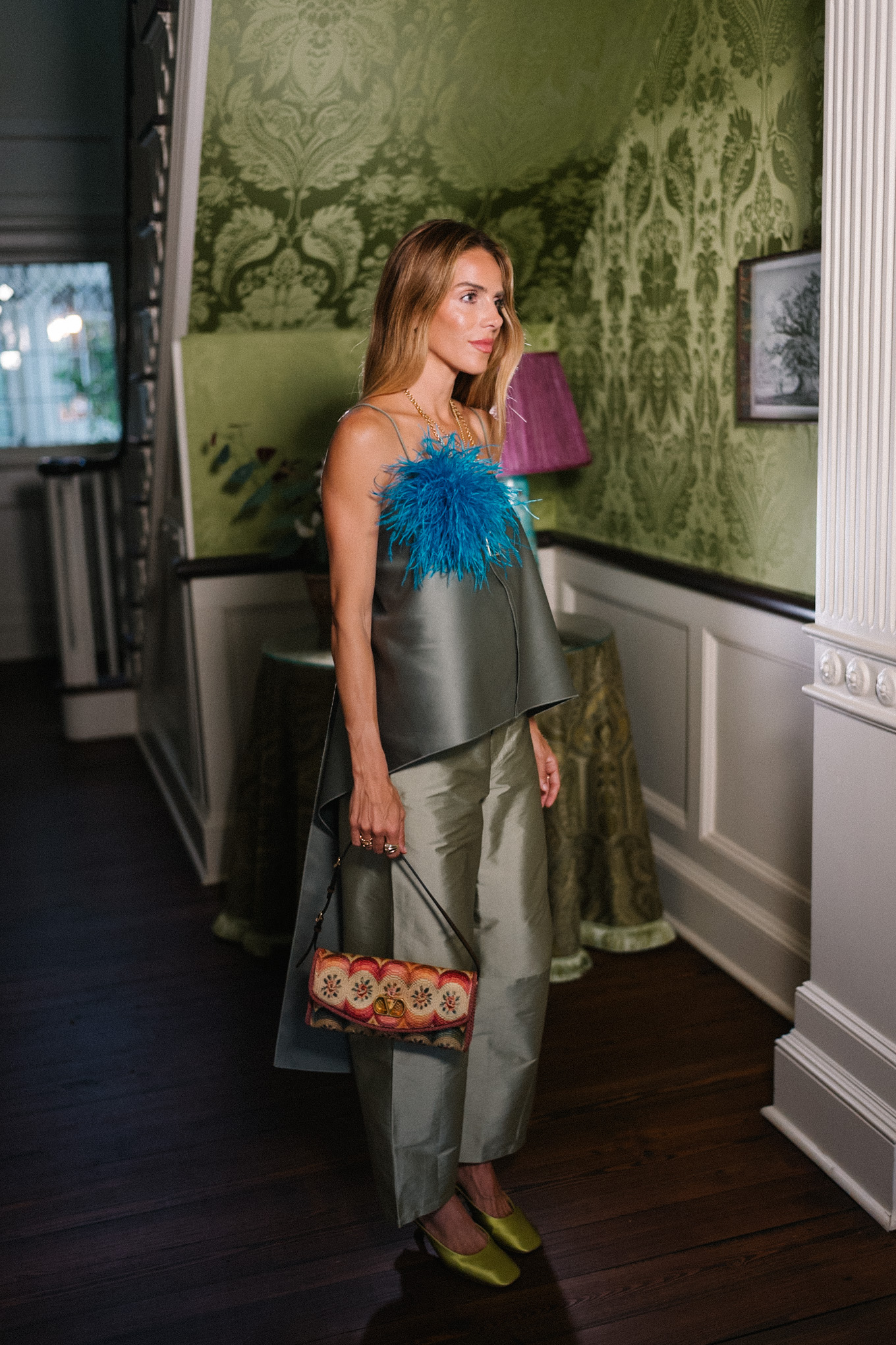 green tank top green taffeta barrel pants blue feather brooch