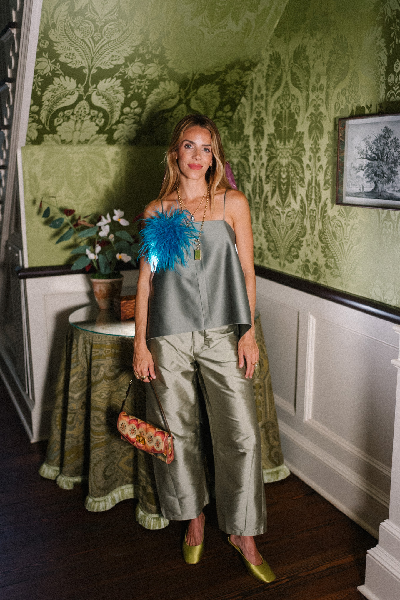 green tank top green taffeta barrel pants blue feather brooch