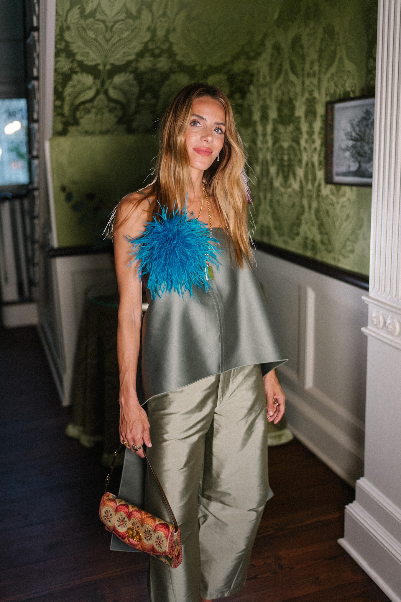 green tank top green taffeta barrel pants blue feather brooch