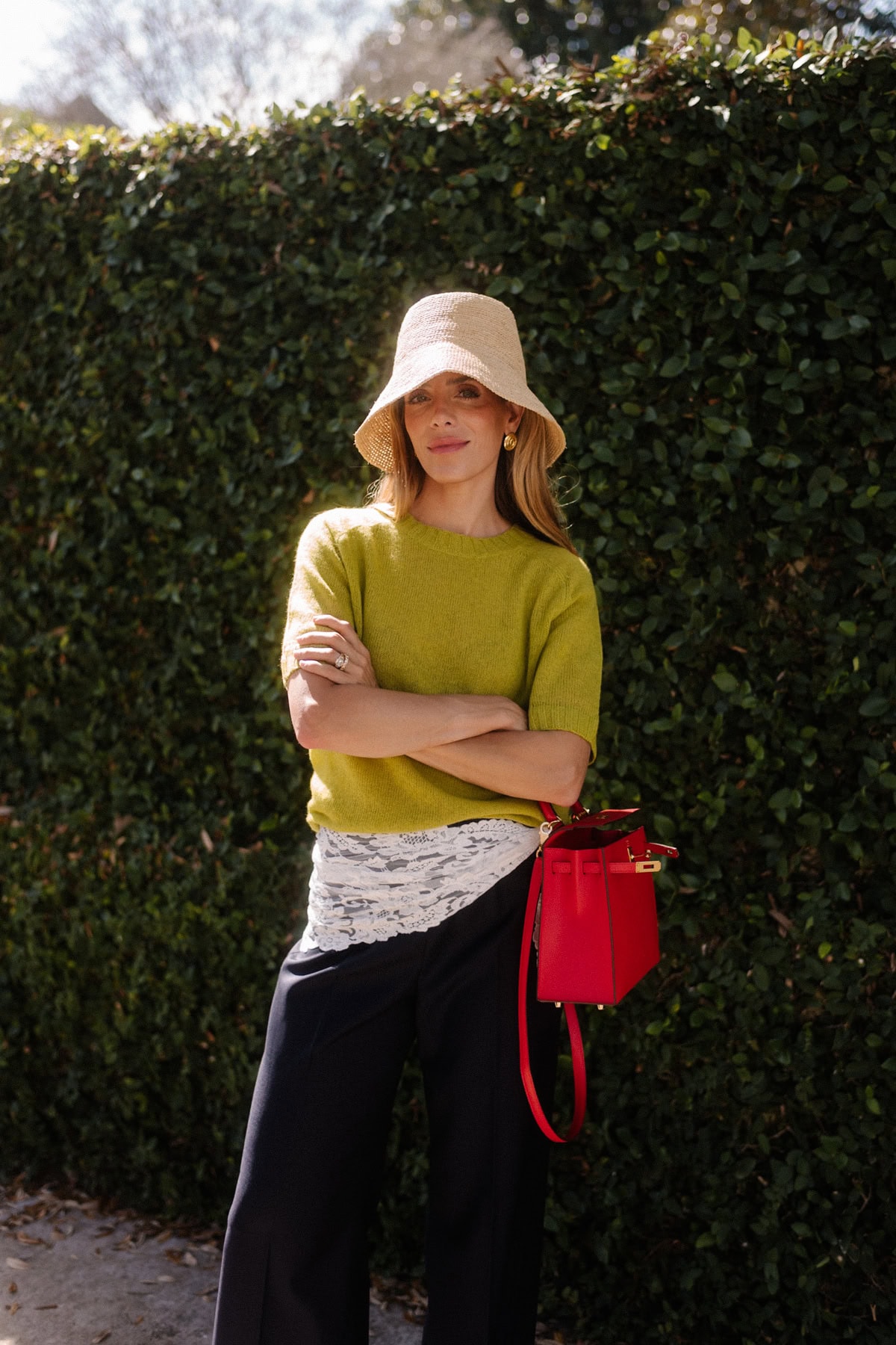 chartreuse short sleeved sweater raffia bucket hat lace and silk pants red handbag chartreuse heels